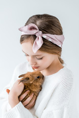 close-up view of beautiful teenage girl holding adorable furry rabbit isolated on white