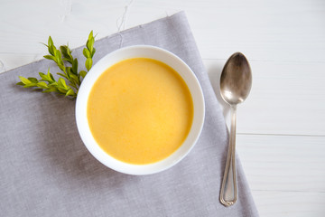 Cream soup in white plates with a silver spoon on a linen napkin. The concept of healthy eating, weight loss, diet, health care