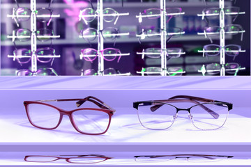 Piękne okulary na półce w salonie optycznym, fiolet. - obrazy, fototapety, plakaty