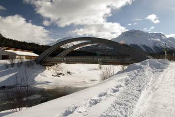 A view of a modern concrete bridge in the snowy alps switzerland