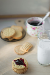 cookies with filling next with a glass of milk nicely at home, on top of the jam