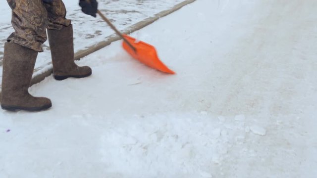Janitor cleaning the yard of snow