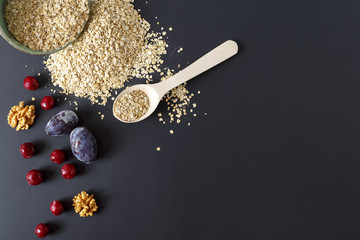 Raw oatmeal with fruit on a dark background