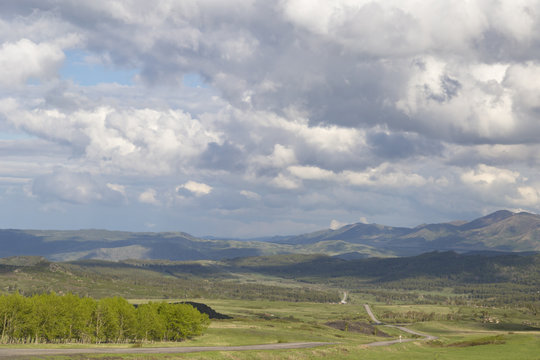 Country road in the mountains under the sky with clouds and clouds