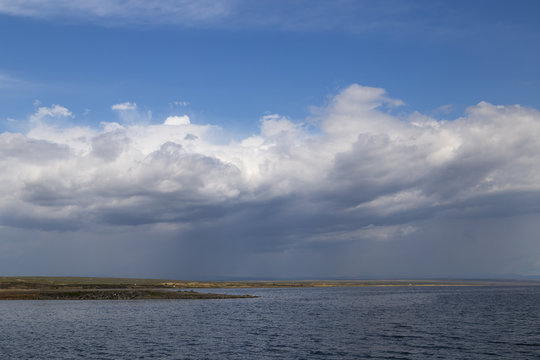 A large reservoir ( lake ) in Kazakhstan under a cloudy and rainy sky