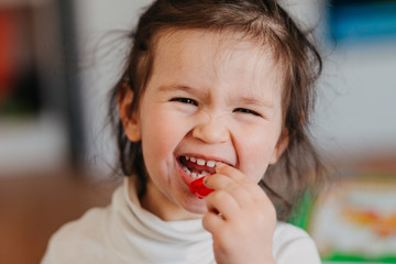 a little girl eating a jelly candys