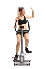Obraz premium Woman exercising on a cross-trainer machine and making a high-five gesture
