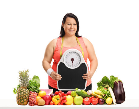 Overweight woman with a weight scale and a measuring tape