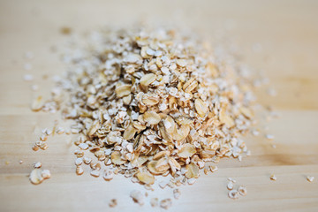 Heap of oat flakes on a on a wood background