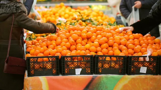 People choosing fruit in supermarket