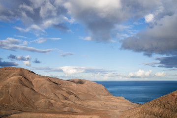 Fototapeta na wymiar arid coastal scenery against beautiful sky and blue ocean