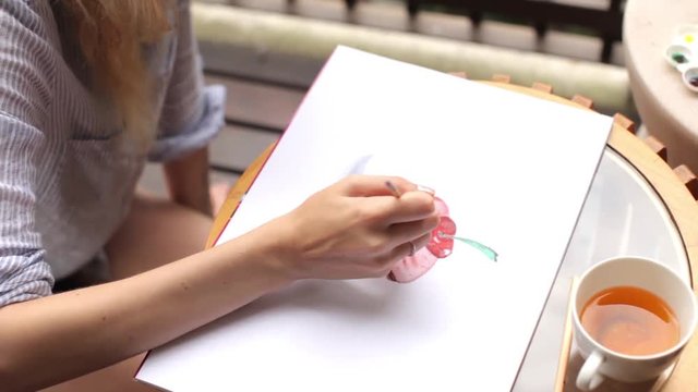 woman draws a capcake on the terrace in the summer