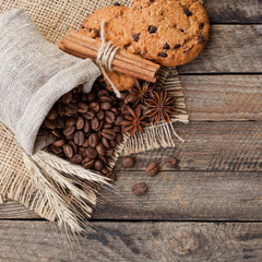 Fototapeta na wymiar Coffee beans with biscuits and spices on a wooden background