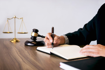 Male lawyer or judge working with Law books, gavel, report the case on table in modern office, Law and justice concept