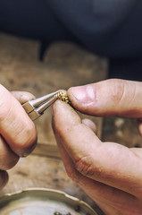 jeweler produces gold jewelry in the workshop