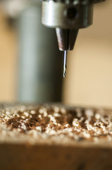 Close up of a drill bit in a chuck on a drill press.