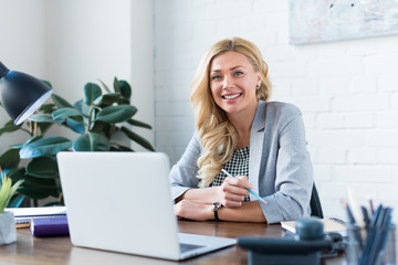 smiling businesswoman looking at camera in office