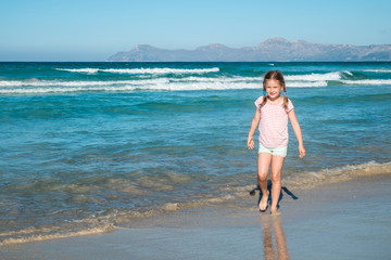 Fototapeta na wymiar Cute girl walking on the beach
