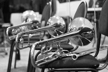 Trombones lying on chairs in black and white tones