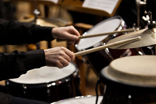 Hands of a man playing a drum set