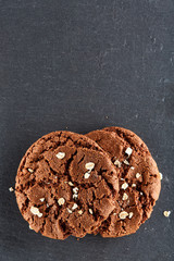 Chocolate chips cookies isolated on black background, macro, close-up, vertical