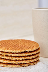Cup of coffee and waffles isolated on the white background, close-up, vertical, selective focus.