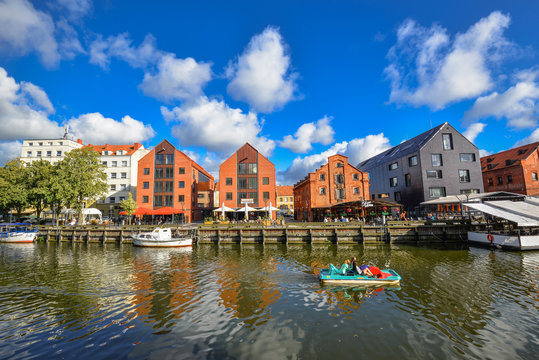 Klaipeda, Lithuania - August 18, 2017: Beautiful view on tourist boat, Dane river, embankment and red brick houses Klaipeda, Lithuania. Summer view on Dane river.
