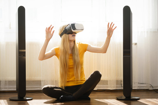 Girl wearing virtual reality goggles at home