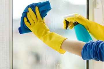 Hand cleaning window at home using detergent rag
