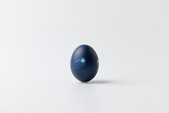 One blue painted easter egg on white