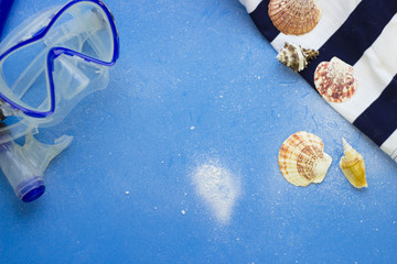 Blue background with a diving mask and shells. Space for text.