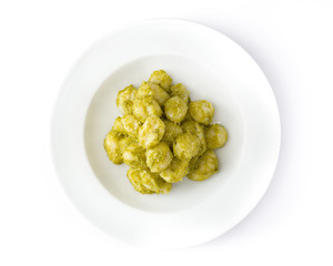 Gnocchi with pesto sauce in plate isolated on white background. Top view