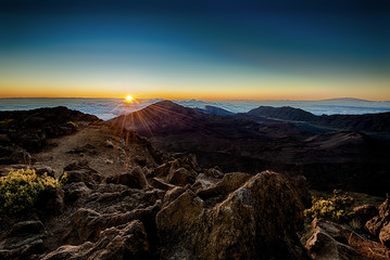 Sunrise from the summit of Maui's volcanic Mt. Haleakala.  Mauna Loa on the Big Island is visible on the right poking thru a sea of clouds.