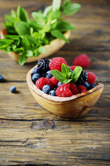 Mix of summer berries and mint on the wooden table