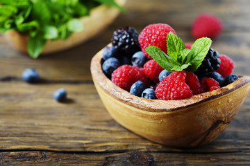 Mix of summer berries and mint on the wooden table