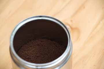 Coffee grounds in a white cup on  a wooden table for breakfast