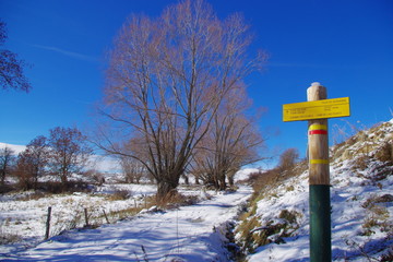 Poteau de randonnée sur neige et balisage rouge et jaune