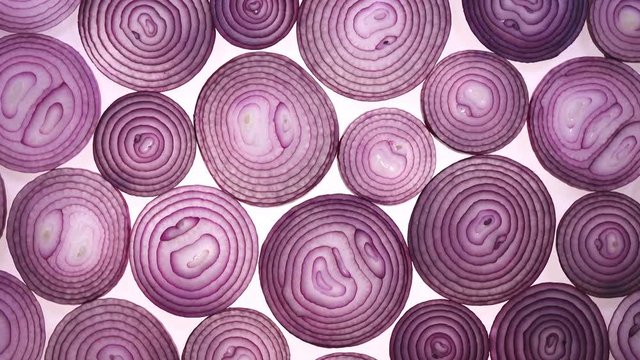 Sliced red onion rotation on white background in 4K. Top view.
