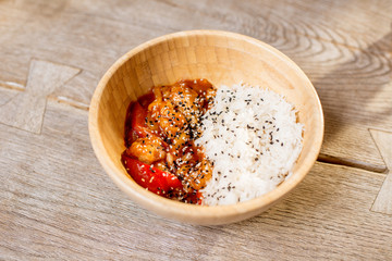 Asian wok rise meal served in the wooden plate on the table