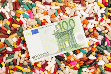 Hundred euros on a pile of various pills.