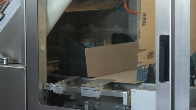 Food packing and sorting industry equipment. Pack the product. Cardboard boxes on conveyor belt in factory. Automated conveyor systems , modular conveyors and industrial automation.