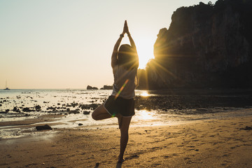 Fototapeta na wymiar Woman balancing in yoga pose on beach