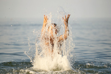 Spray with water. Girl having fun bathing in the sea.