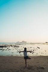 Sportive woman balancing on beach practicing yoga