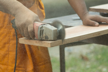 A carpenter is Sawing the wood.