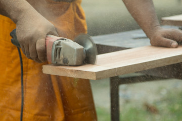 A carpenter is Sawing the wood.