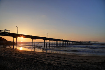 Fototapeta na wymiar The sunset over the Ocean Beach Pier near San Diego, California.