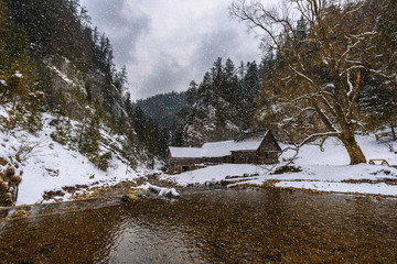 Old wooden water mill in winter with snow falling © Nick Fox