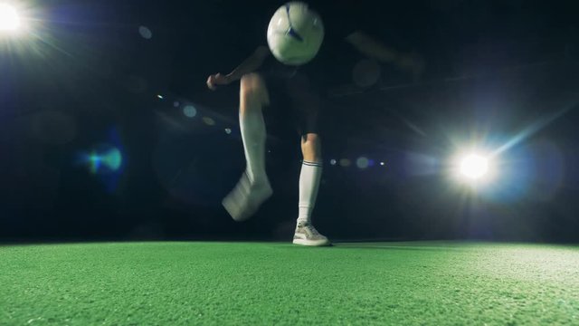 Professional soccer player is juggling and making tricks, view from below. 