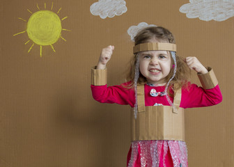 Portrait of emotional little girl with a cardboard suit. handmade. background of painted sun and...